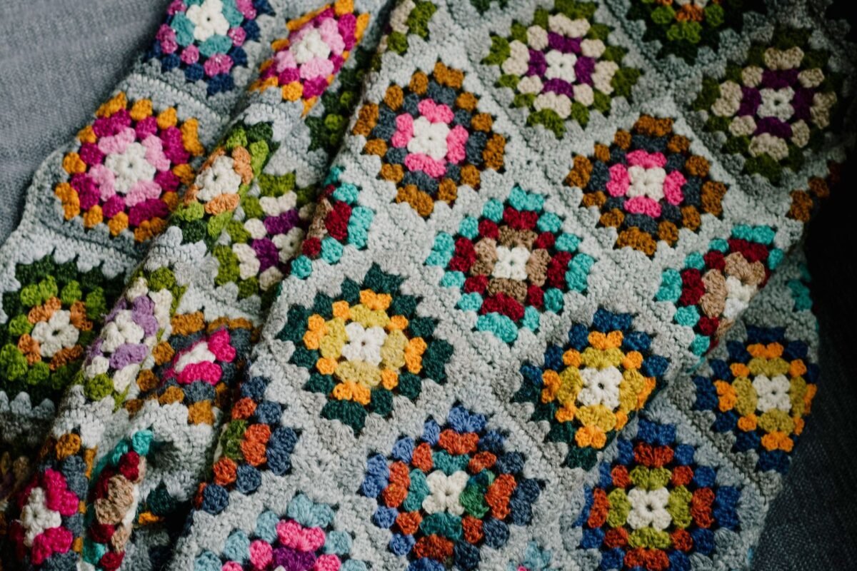 Close up of a crochet blanket made of joined granny squares in bright colours