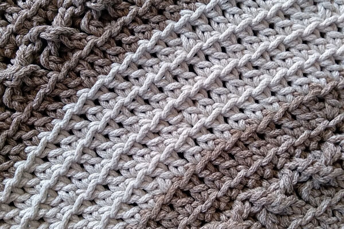 Close up of textured crochet stitches in taupe and cream showing the V shaped stitch tops