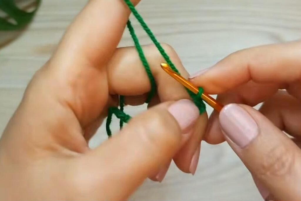 Slip knot and starting chain in dark green yarn for the gift bag base