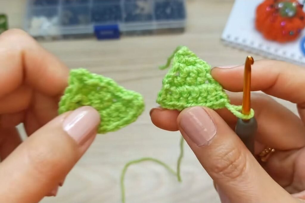 Small crochet christmas tree tier of 7 stitches next to a second tier in progress