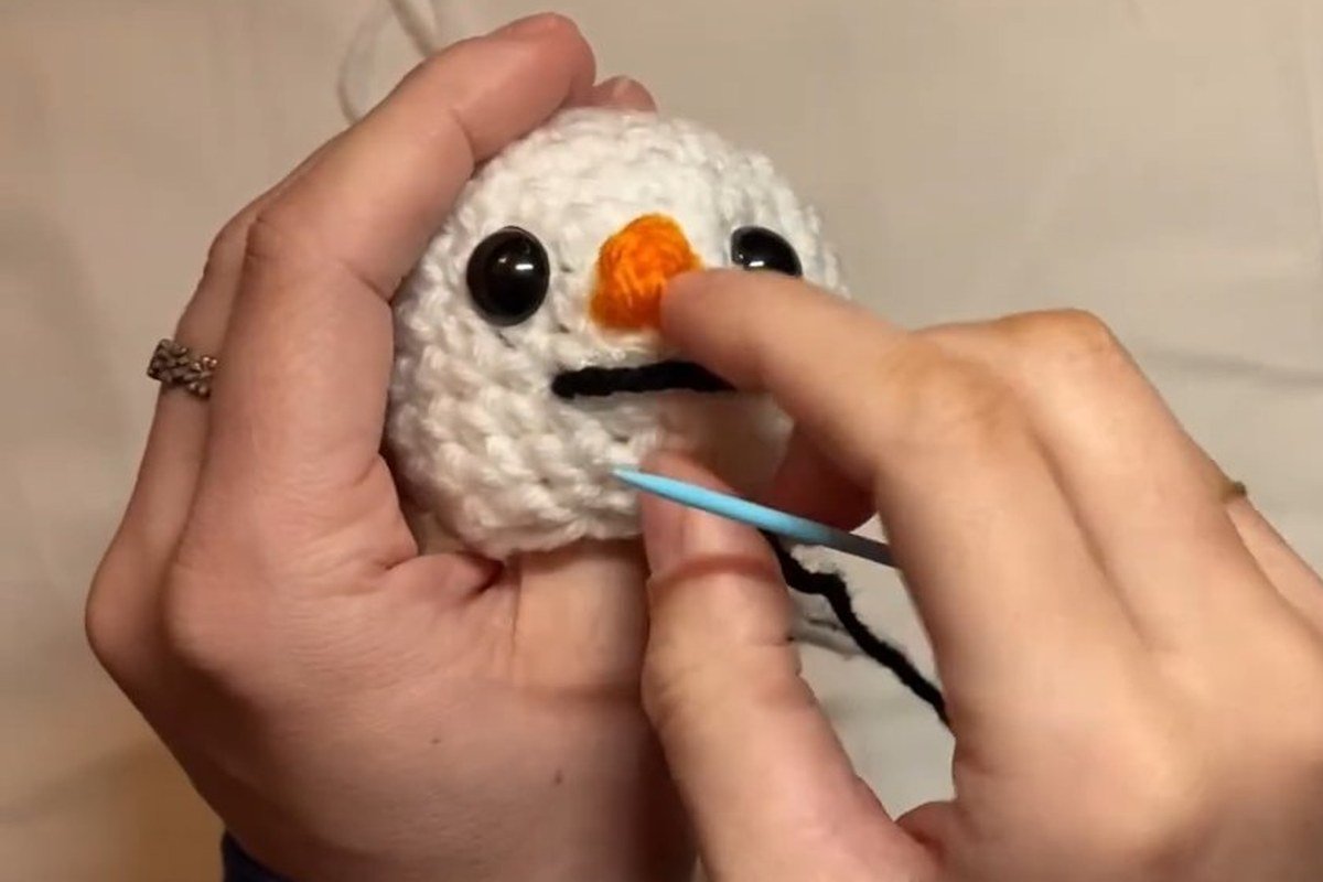 embroidered smile on the head of a free crochet snowman pattern