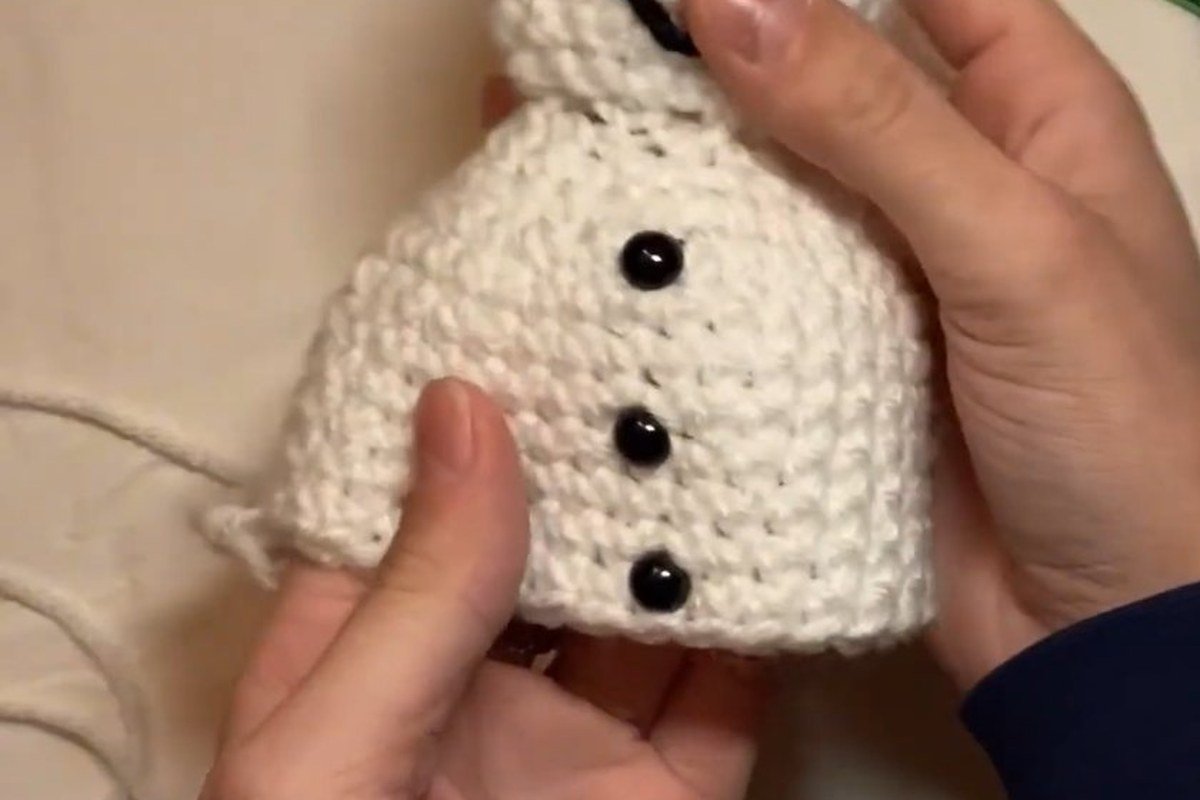 three black buttons on the body of a free crochet snowman pattern