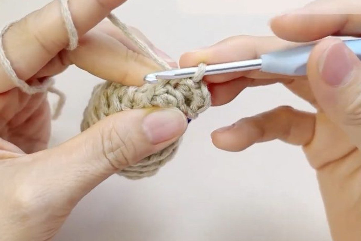 first scales of a free crochet pinecone pattern worked around the bottom of the core