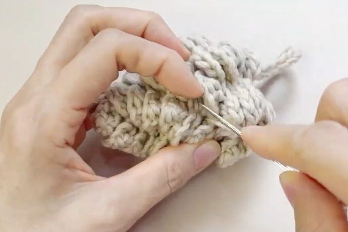 weaving in the ends of a finished free crochet pinecone pattern