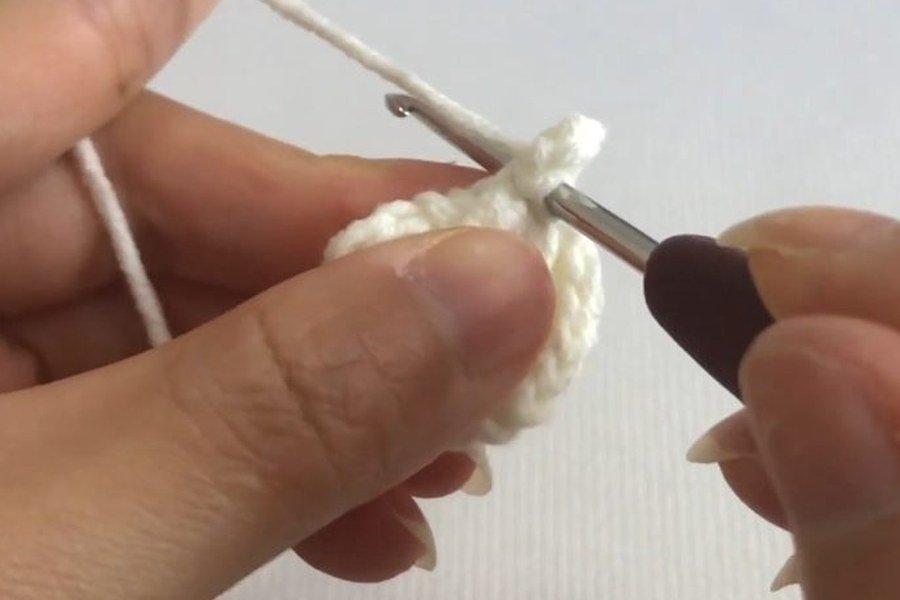 chain four, then hook into the puff chain of a puff stitch crochet snowflake
