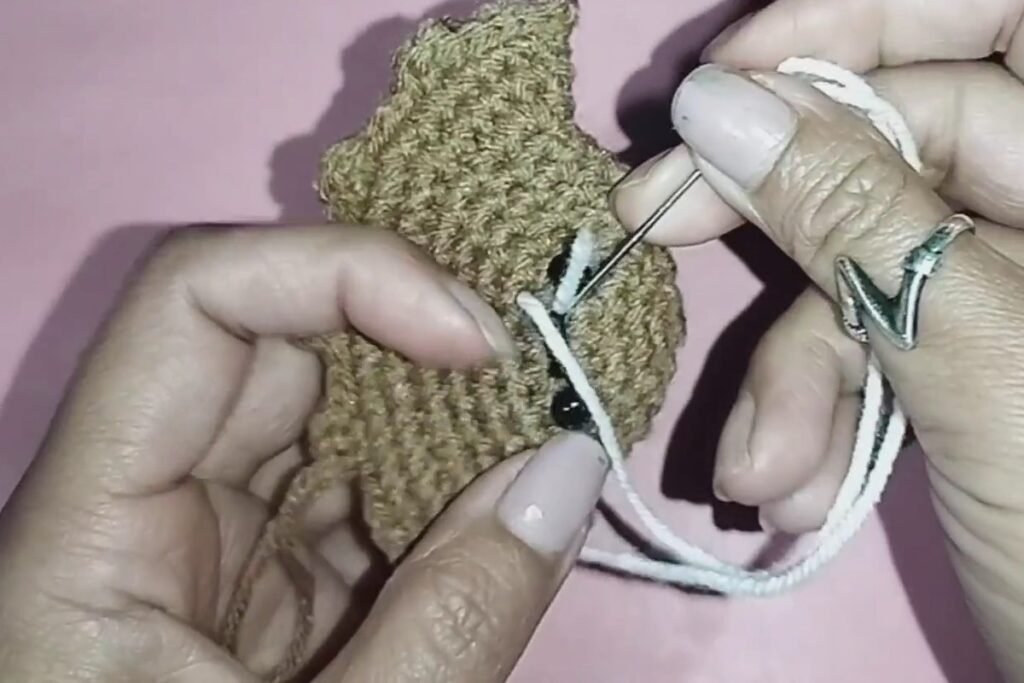 white yarn fangs stitched onto a crochet bat keychain