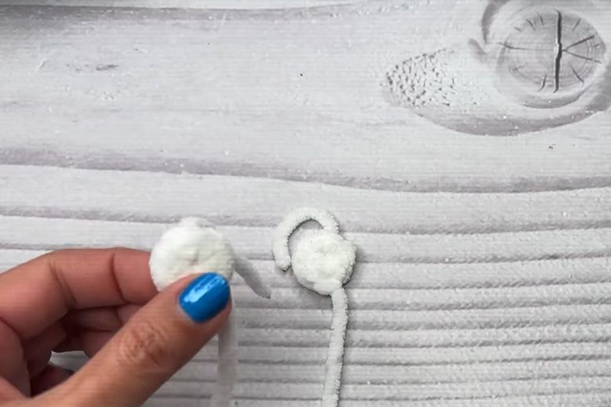 two white crochet bat eyes with yarn tails