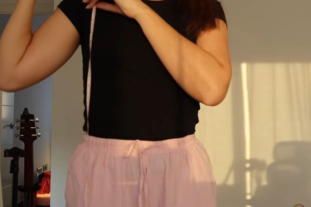measuring the cardigan length from the shoulder seam with a tape measure