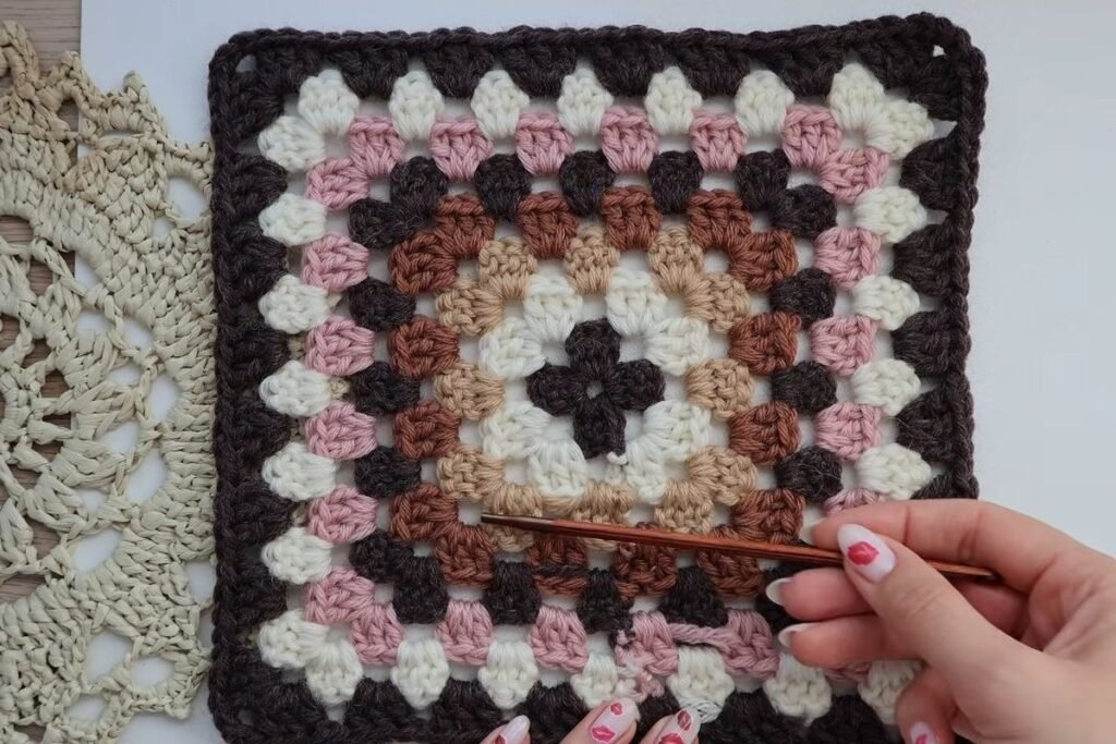 one finished 8 round granny square for the crochet granny square cardigan with a brown border