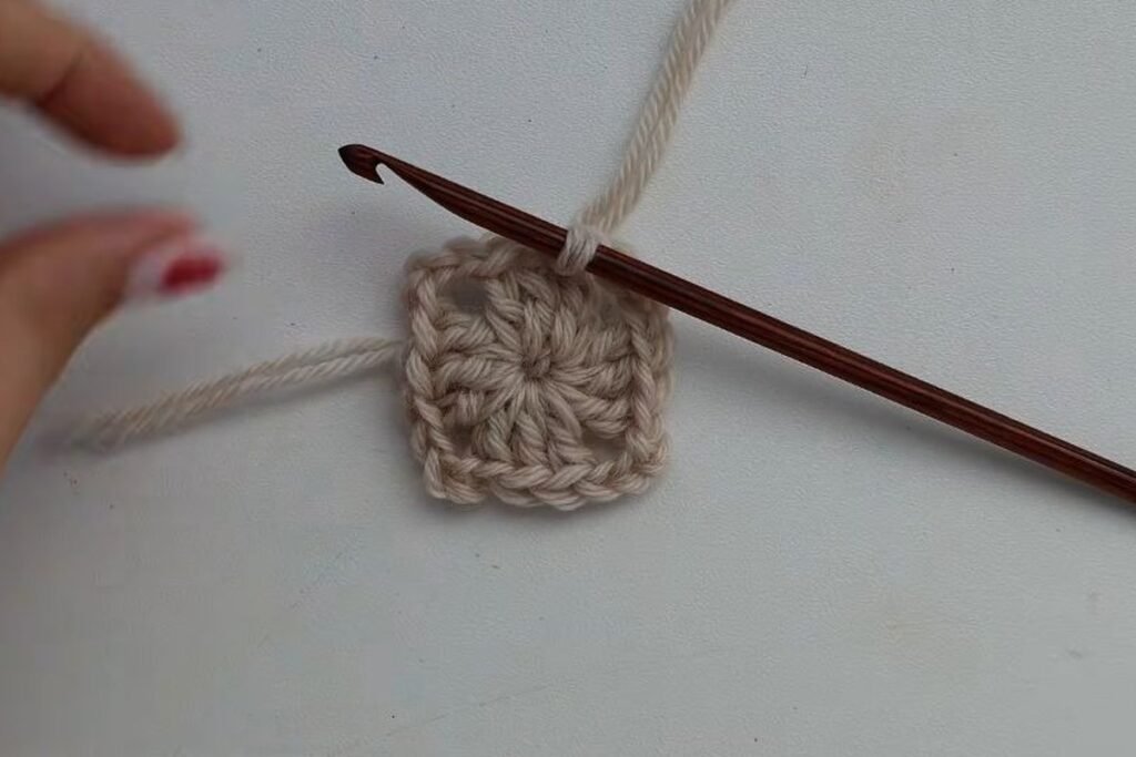 round 1 of the granny square: four clusters of double crochet around a magic ring