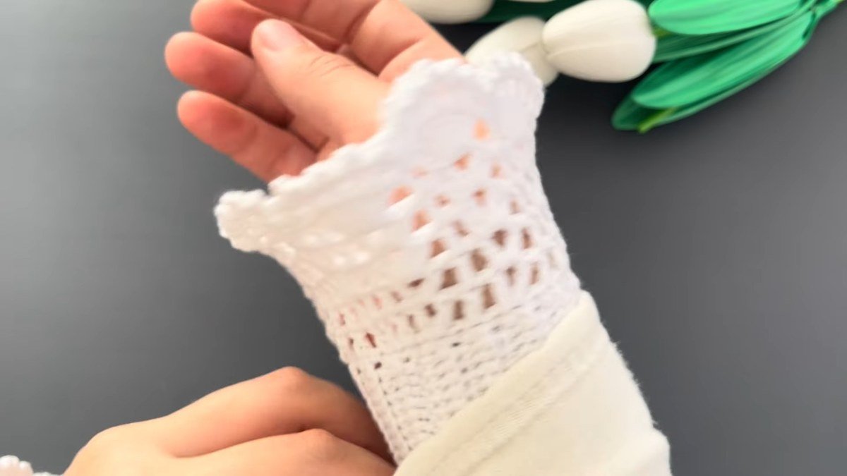 white crochet lace wrist cuffs worn on the wrist over a cream sleeve