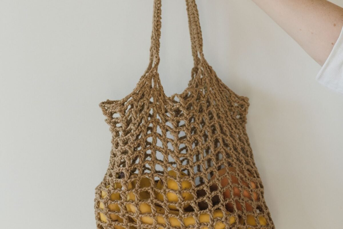 Crochet mesh market bag held up and stretched by a load of fruit