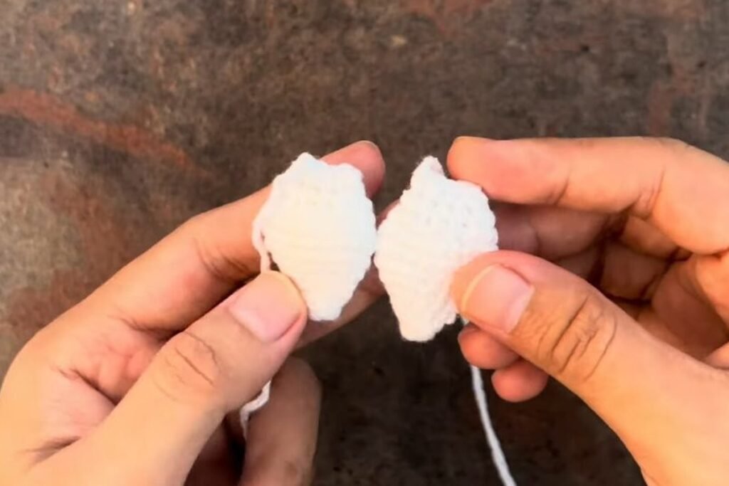 two finished white crochet owl wings held side by side