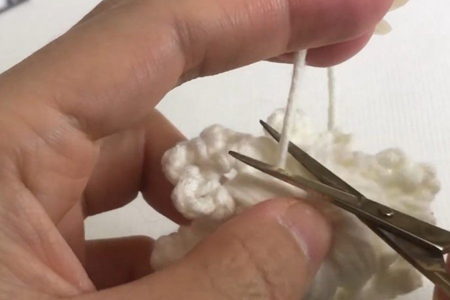 cutting the yarn tail of the puff stitch crochet snowflake