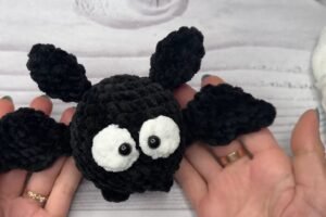 finished black crochet bat from a free crochet bat pattern with white eyes and small wings