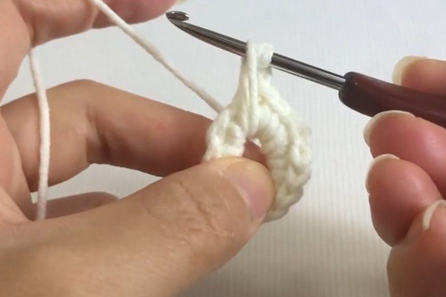 first incomplete half double crochet of the puff stitch in a puff stitch crochet snowflake
