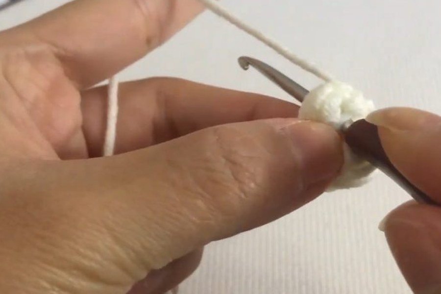first single crochet worked into the ring of a puff stitch crochet snowflake