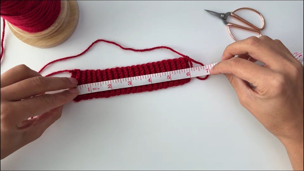 measuring the ribbed cuff of a free crochet fingerless gloves pattern with a tape measure