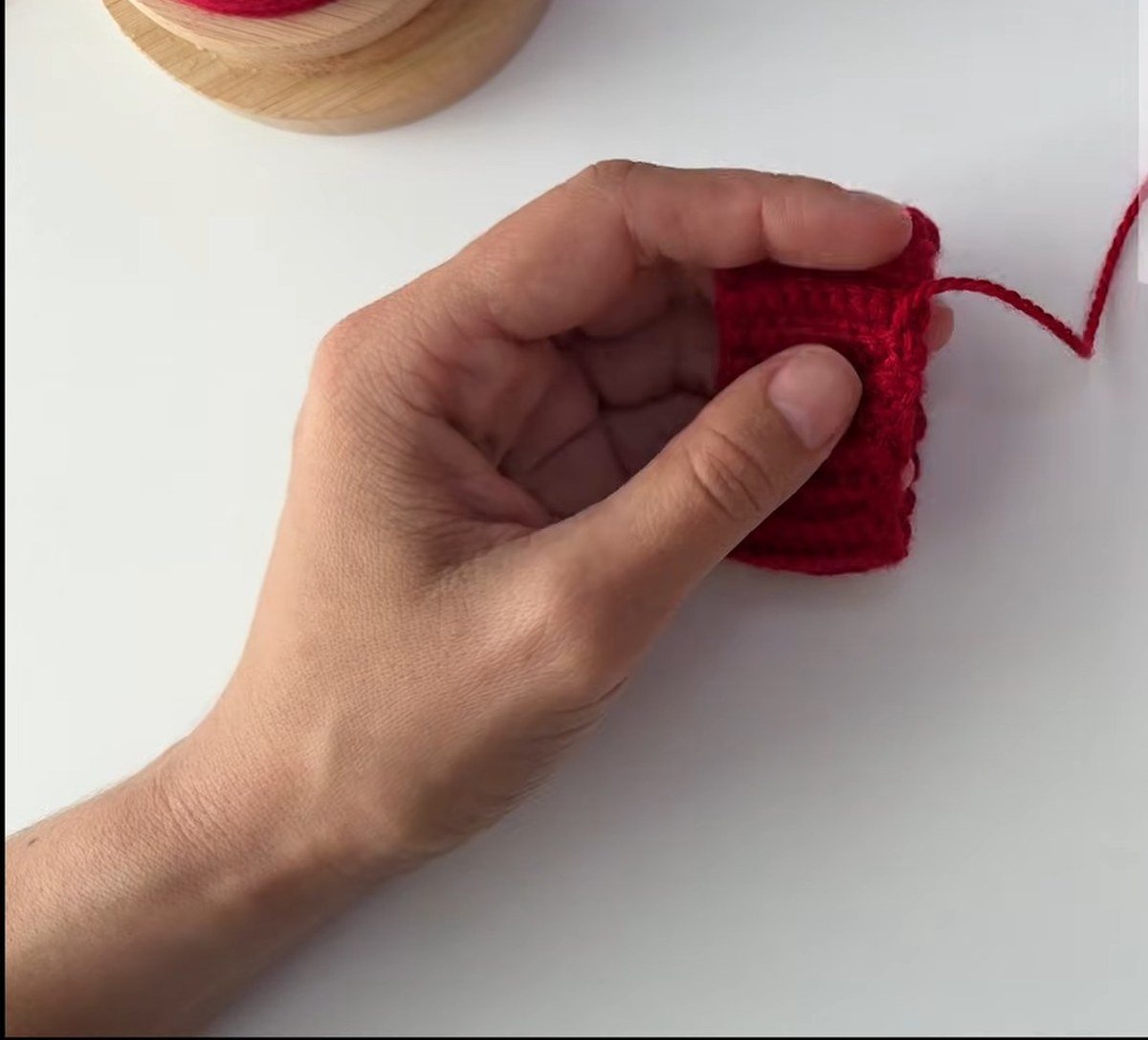 weaving in the tail on the seamed cuff of a free crochet fingerless gloves pattern