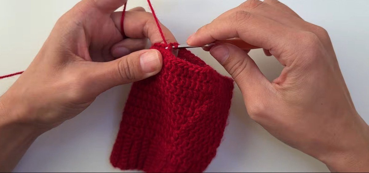 chain-8 bridge that forms the thumb hole in a free crochet fingerless gloves pattern