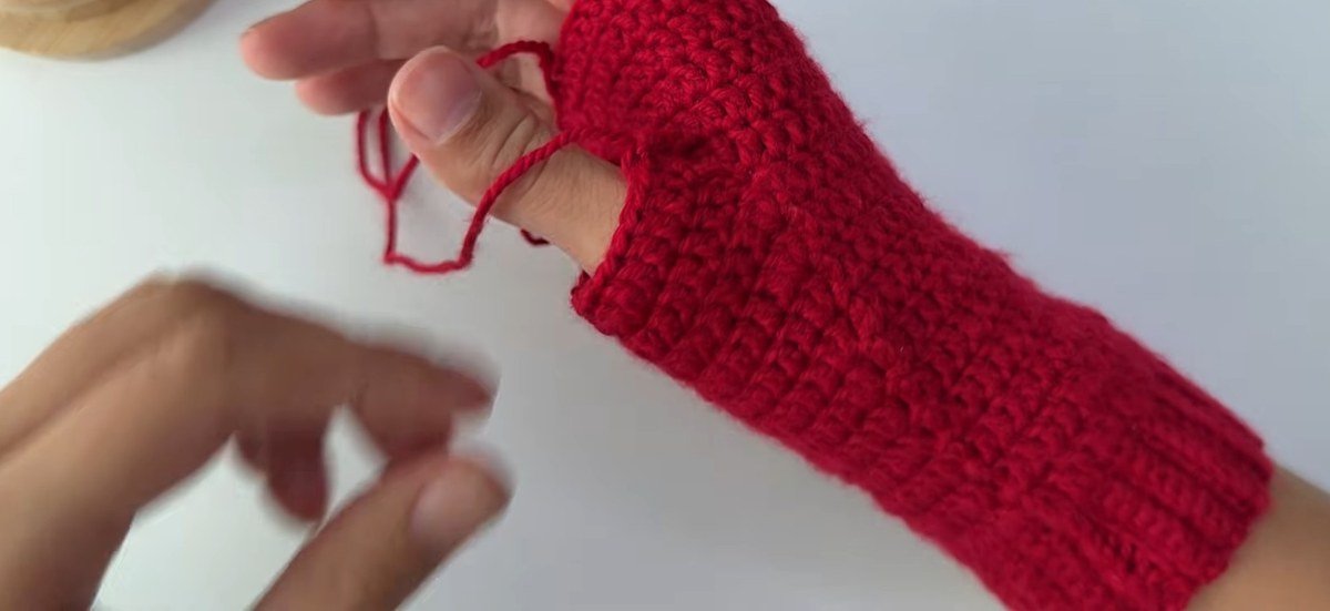 finished thumb and fitted hand of a free crochet fingerless gloves pattern