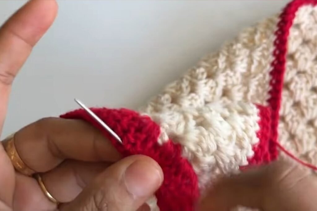 Weaving in the yarn ends of the free crochet head scarf pattern with a needle