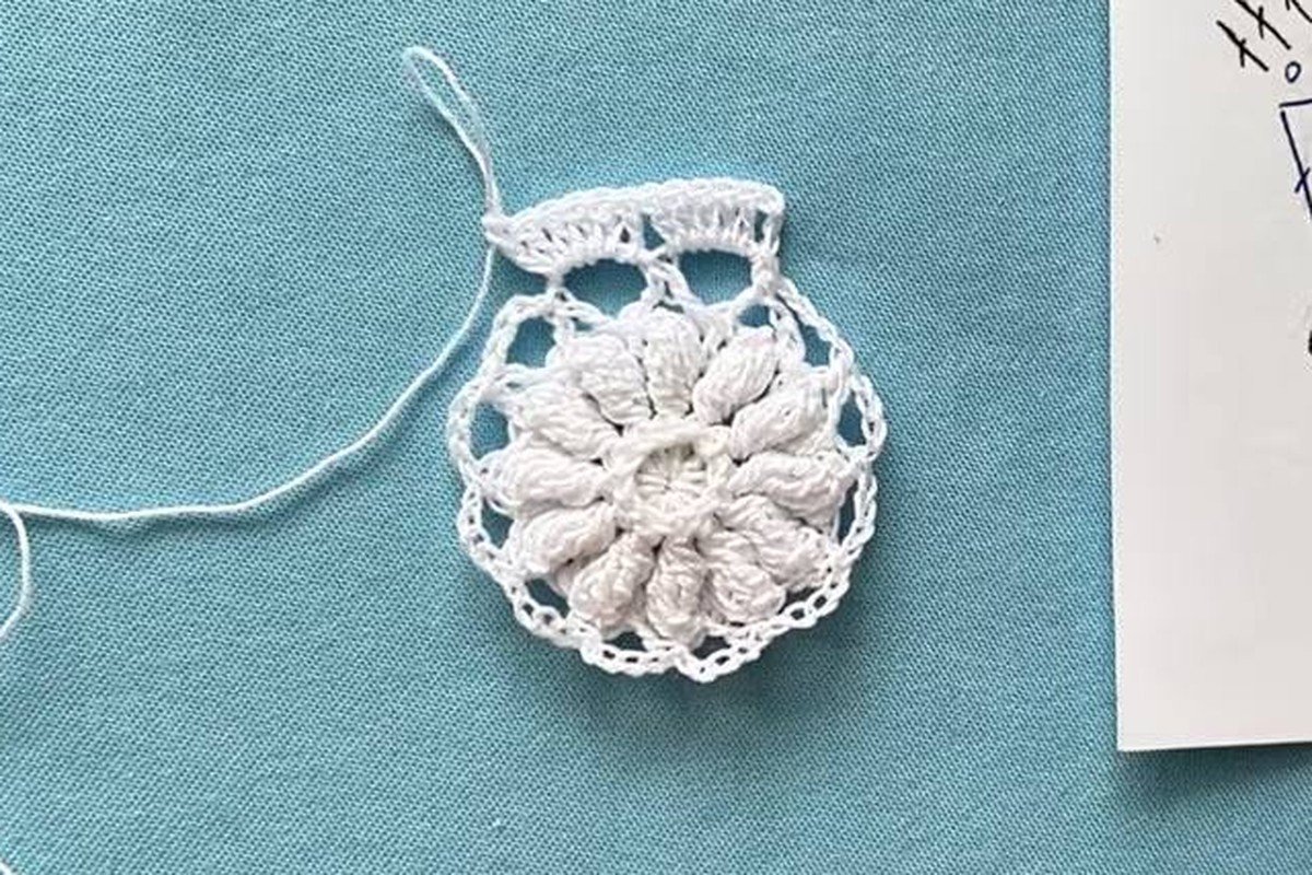 free crochet snowflake pattern disc after round 5 with a solid flower and open outer ring