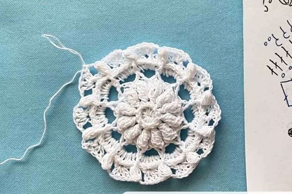 free crochet snowflake pattern after round 7 with puff stitches and a first pointed edge