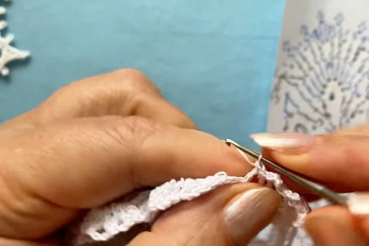 working the picot edge under an arch of a free crochet snowflake pattern