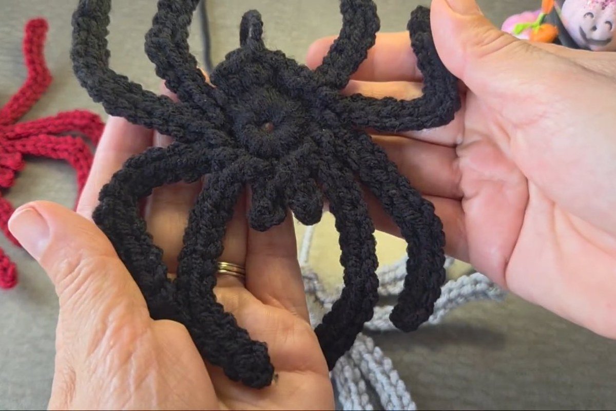 finished black crochet spider held up, made from a free crochet spider pattern