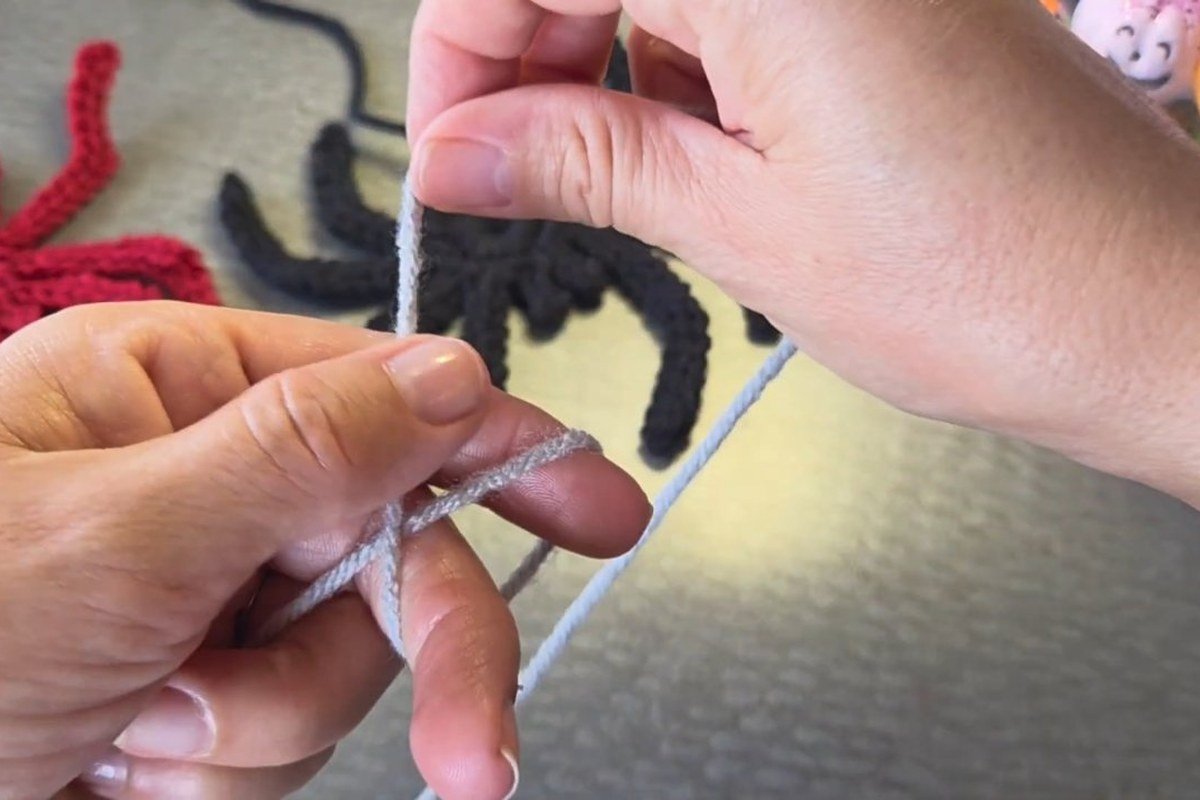 winding yarn round the fingers to start the free crochet spider pattern