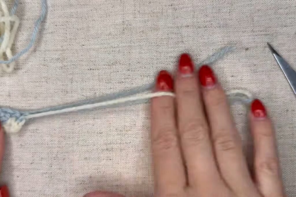 cutting the old yarn colour and leaving a long tail for the tassels