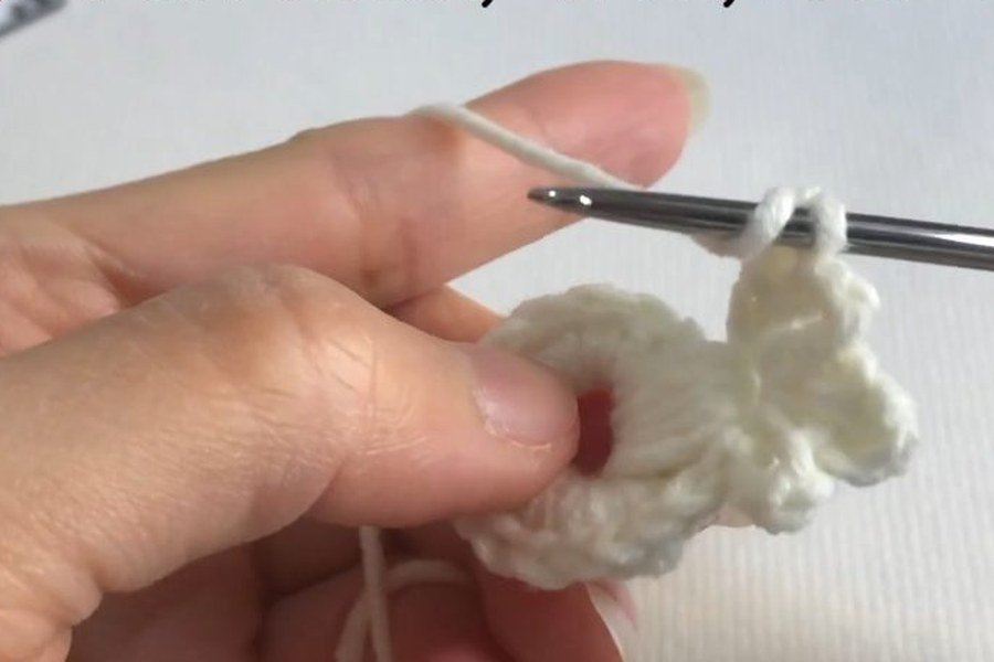 second puff stitch worked into the ring of a puff stitch crochet snowflake