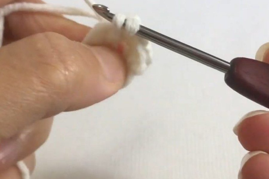 single crochet covering the ring in round 1 of a puff stitch crochet snowflake