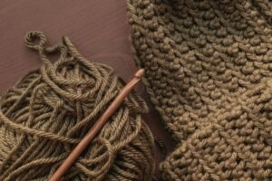 Yarn and a wooden hook ready for a crochet hat for newborns free pattern