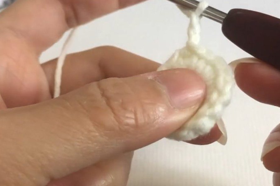 yarn over and hook into the ring to begin a puff stitch on a puff stitch crochet snowflake