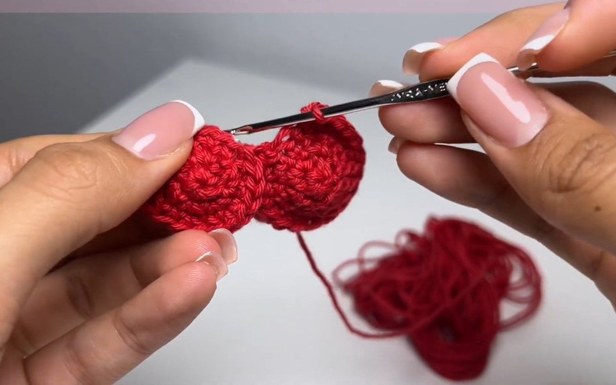 two red circles joined into a heart shape for a crochet cherry keychain