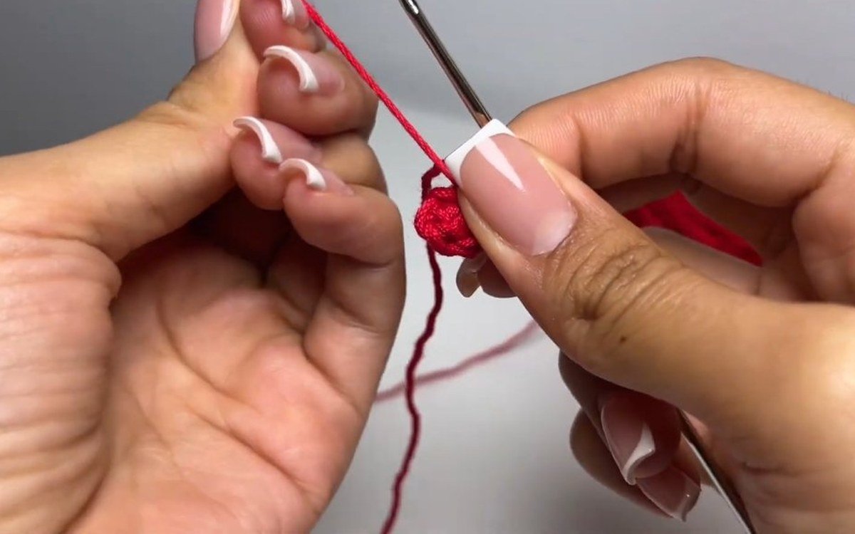 magic circle with 6 single crochet worked in red yarn to start a crochet cherry keychain