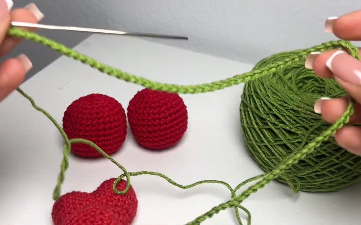 green stem chain of 85 stitches joining two cherries on a crochet cherry keychain