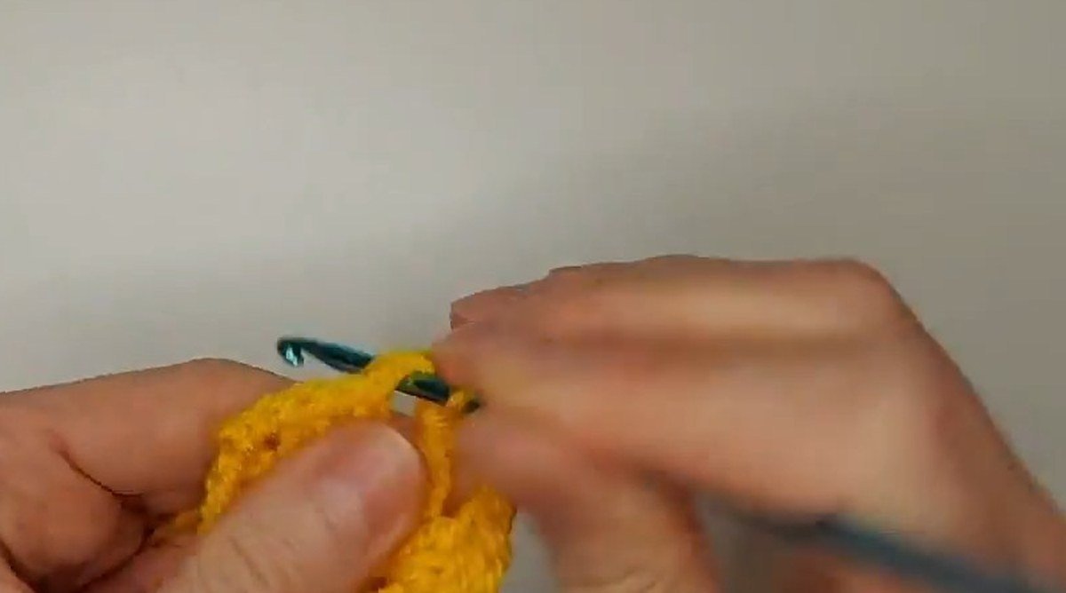 granny square growing round by round on the hook for a crochet vest pattern