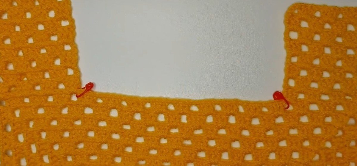 front panel with the finished strap standing up from the granny square, crochet vest pattern