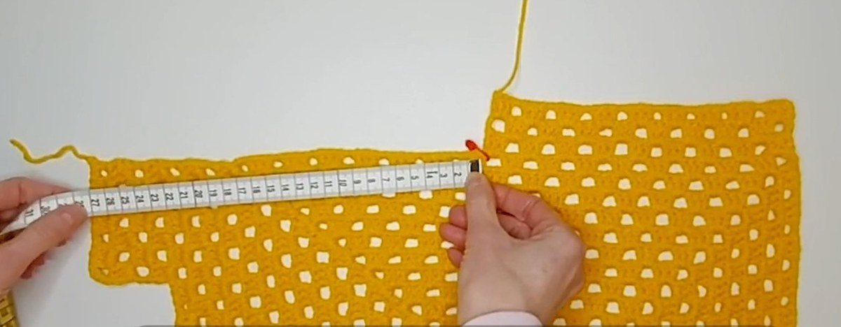 measuring the side rows of a granny square panel for a crochet vest pattern
