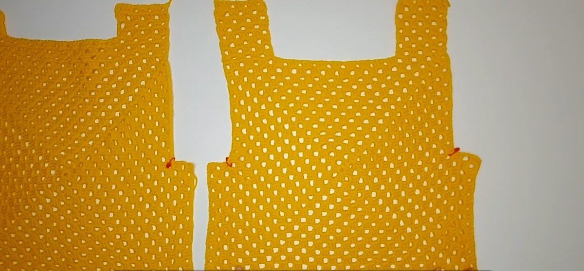 front and back panels of a crochet vest pattern laid next to each other with their side sections