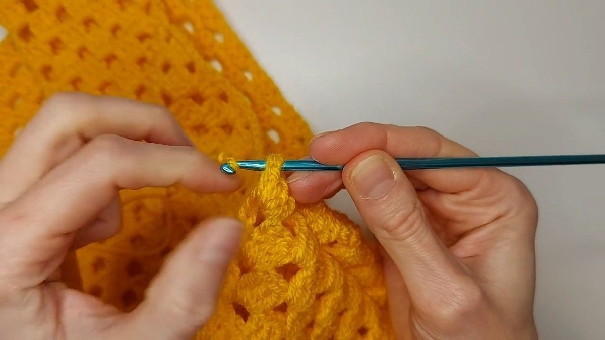 yarn attached at the armhole edge to start the ribbing on a crochet vest pattern